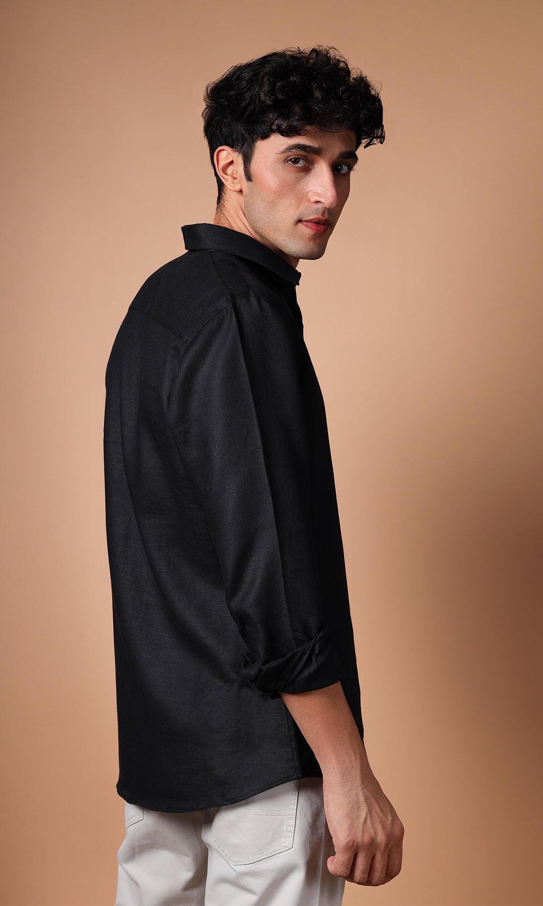 Side view of a model in a black linen shirt, illustrating the impeccable fit and finish.