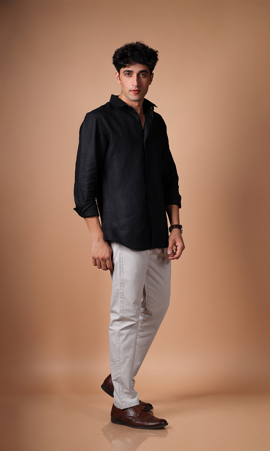 Front view of a black linen shirt on a model, perfect for a sleek, contemporary style.