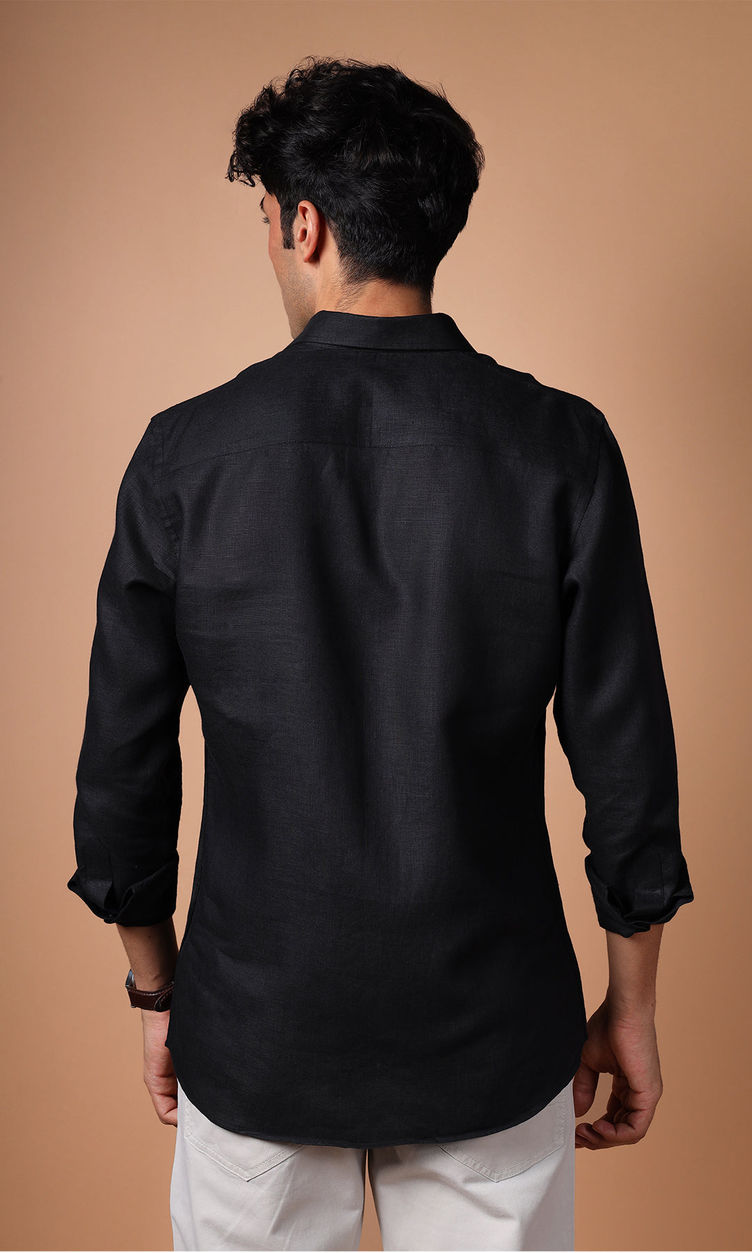 Close-up of a black linen shirt on a model, showcasing the rich color and premium texture