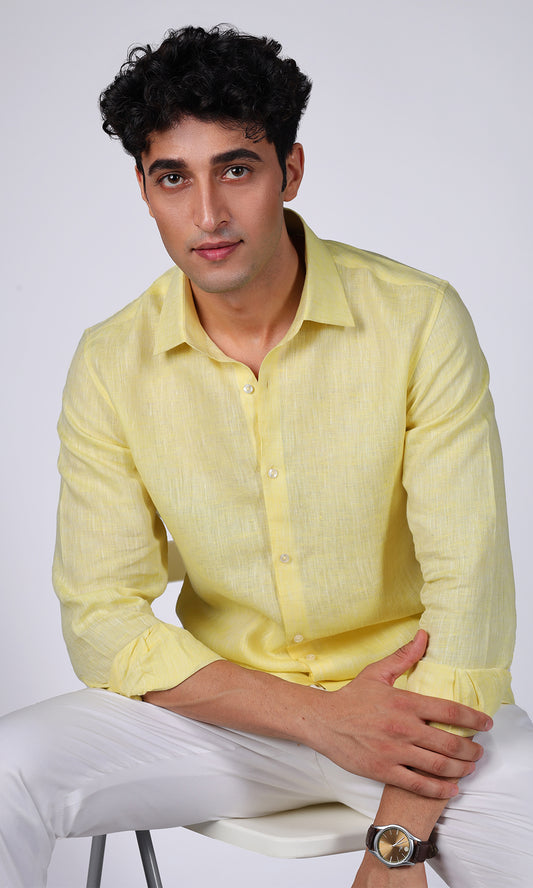 Model in a yellow linen shirt viewed from the side, highlighting the shirt’s clean lines.